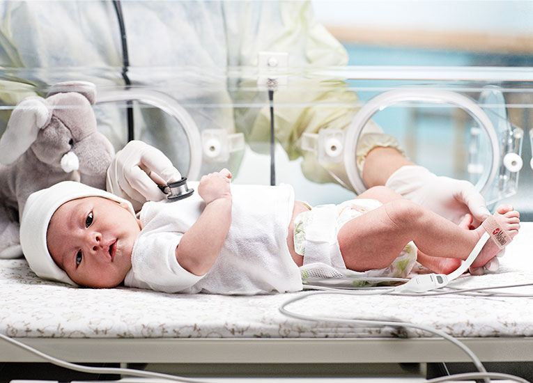 Masimo - baby in hospital bed with Masimo sensor on foot